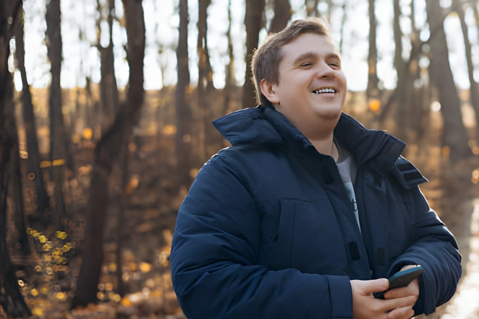 Man laughing on a walk through an autumn forest
